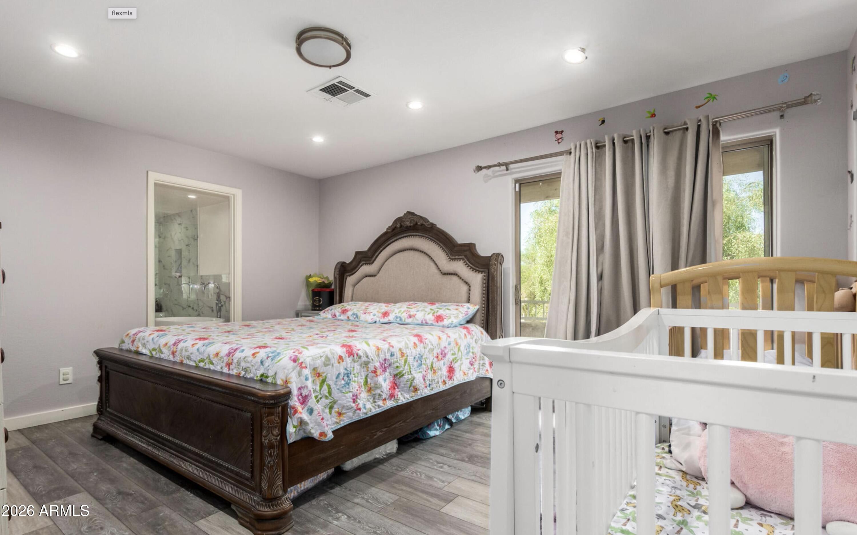 10225 West Camelback Road, Unit 12 Phoenix, AZ 85037 - Photo 10 of 19 a bedroom with a bed next to a large window
