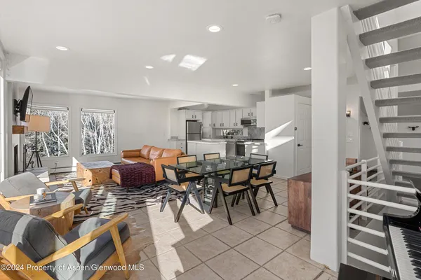 a living room with furniture a flat screen tv and a table