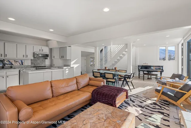 a living room with furniture kitchen view and a table