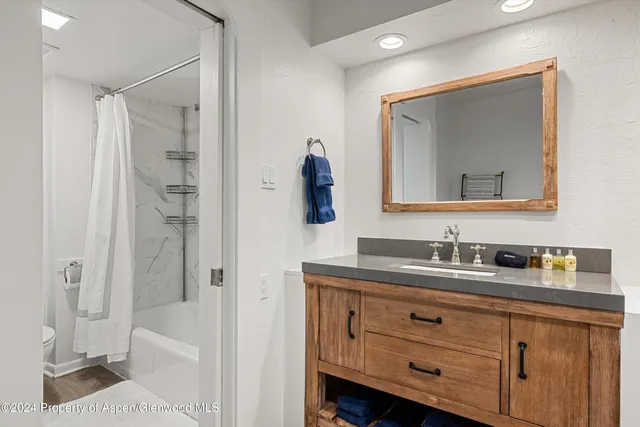 a bathroom with a double vanity sink mirror and toilet