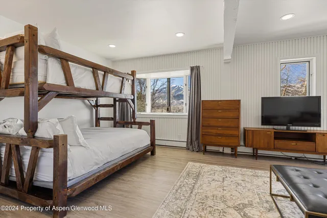 a bedroom with furniture and a flat screen tv