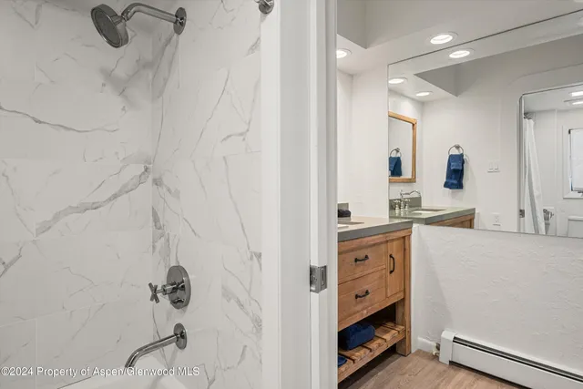 a spacious bathroom with a double vanity sink a mirror and a shower