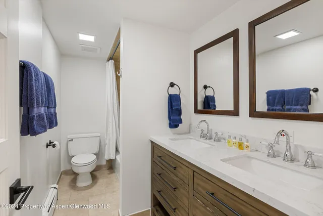 a bathroom with a granite countertop toilet sink and a large mirror