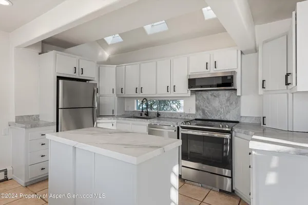a kitchen with cabinets appliances and a counter space