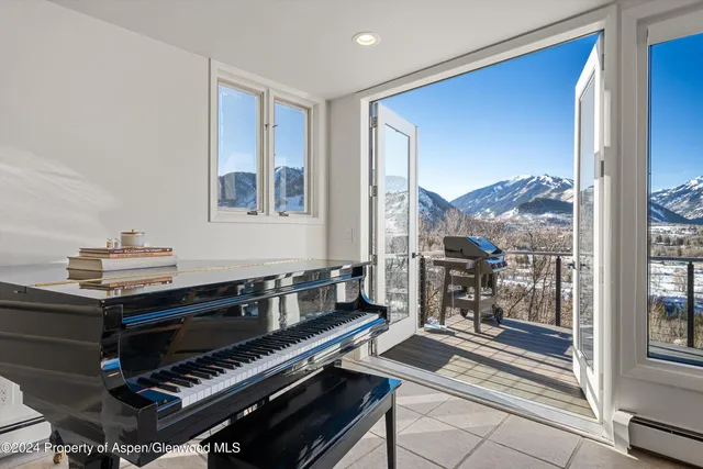 a living room with furniture and a piano