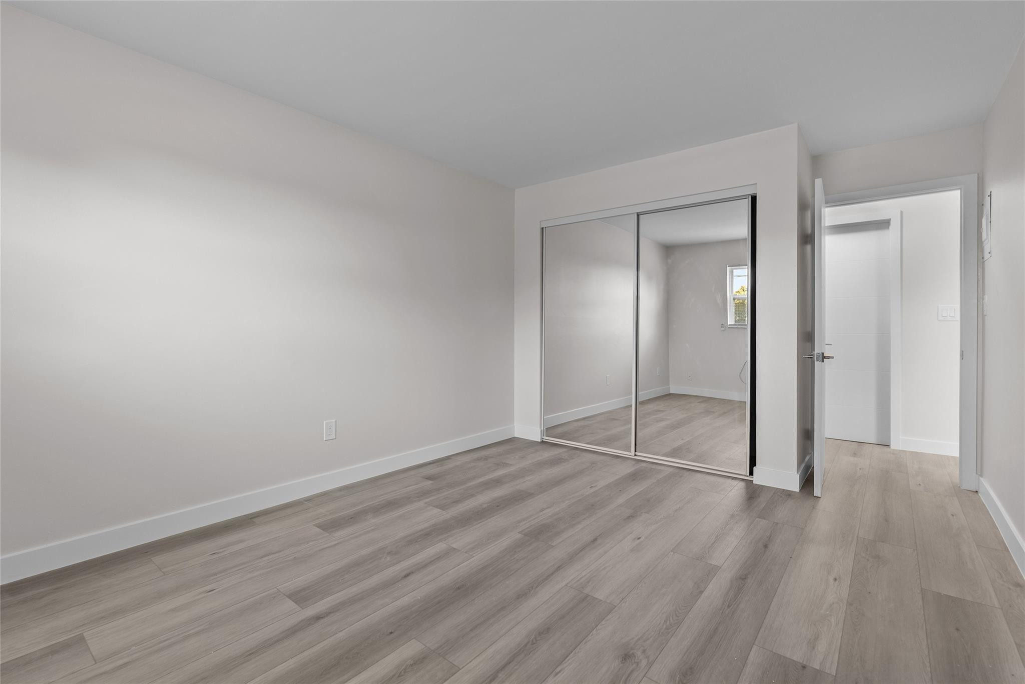 1150 East Sample Road, Unit 202 Pompano Beach, FL 33064 - Photo 11 of 20 wooden floor & wooden door in an empty room