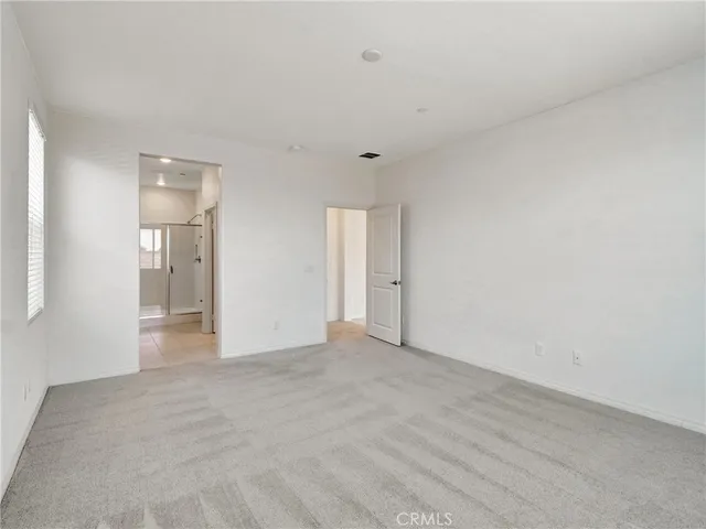 a view of an empty room with closet and a window