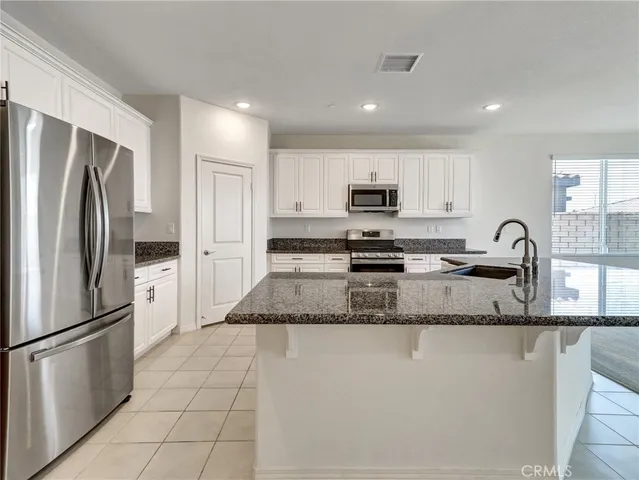 a kitchen with stainless steel appliances granite countertop a refrigerator sink and stove