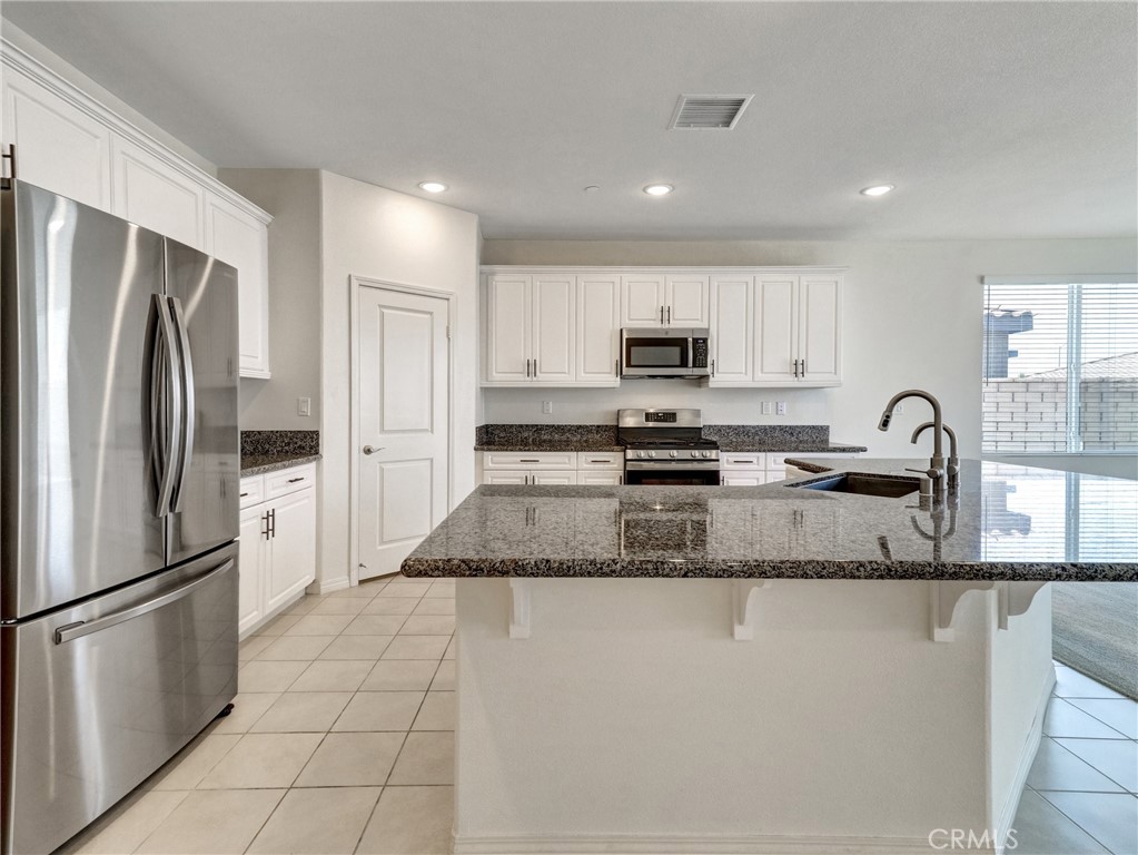 43885 Arancia Way Indio, CA 92203 - Photo 4 of 26 a kitchen with stainless steel appliances granite countertop a refrigerator sink and stove