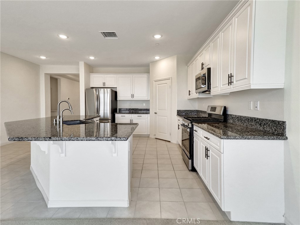 43885 Arancia Way Indio, CA 92203 - Photo 5 of 26 a kitchen with stainless steel appliances granite countertop a sink and a stove