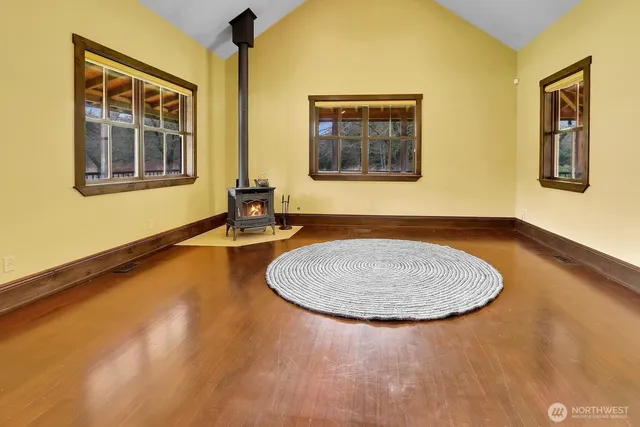 a view of an empty room with window and wooden floor