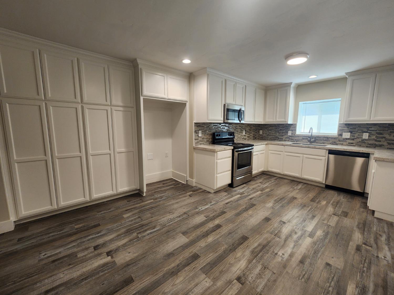 20383 Sutliff Road Escalon, CA 95320 - Photo 19 of 65 a kitchen with stainless steel appliances granite countertop a stove a sink and a refrigerator