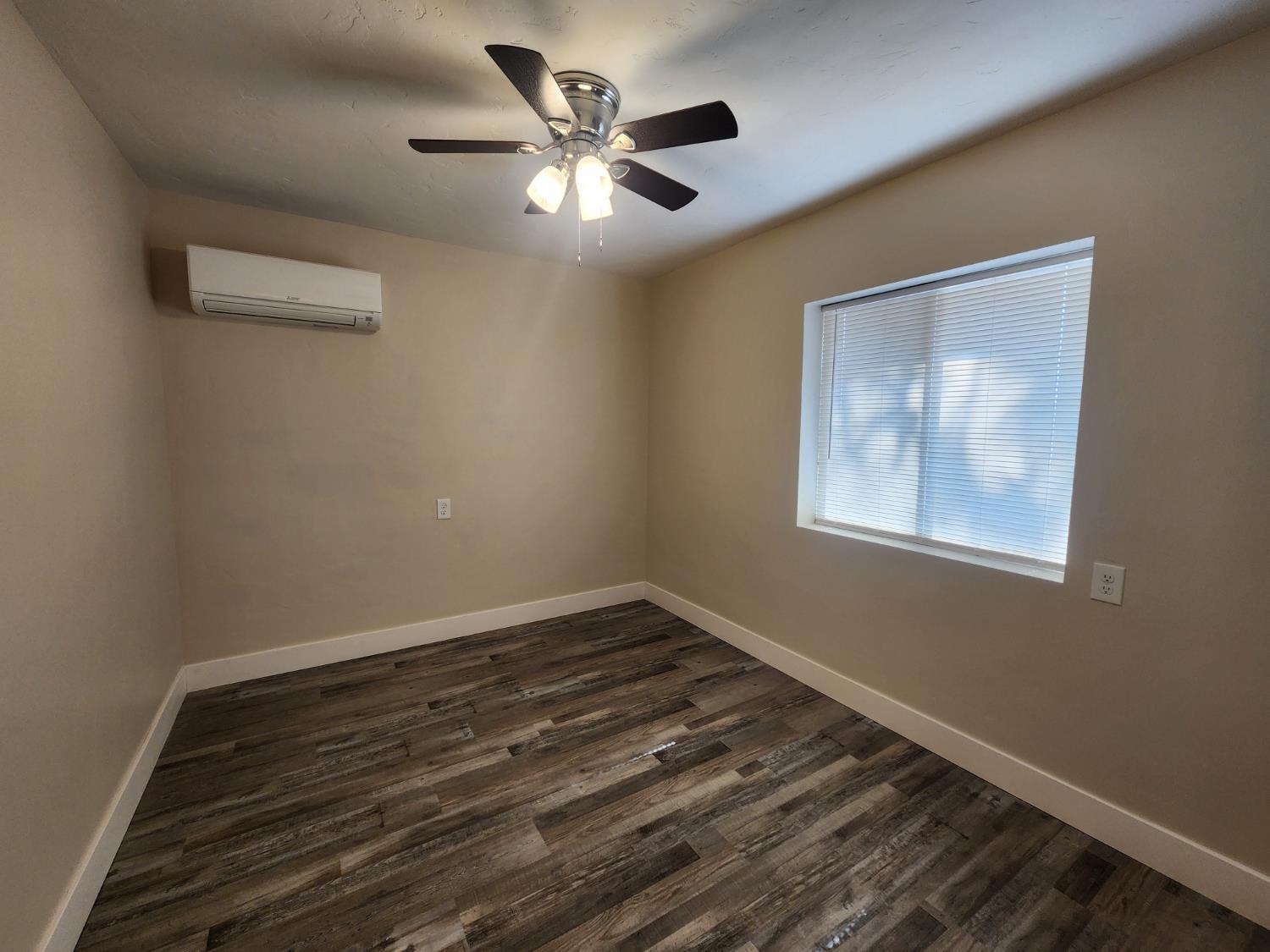 20383 Sutliff Road Escalon, CA 95320 - Photo 30 of 65 a view of an empty room with a window and wooden floor