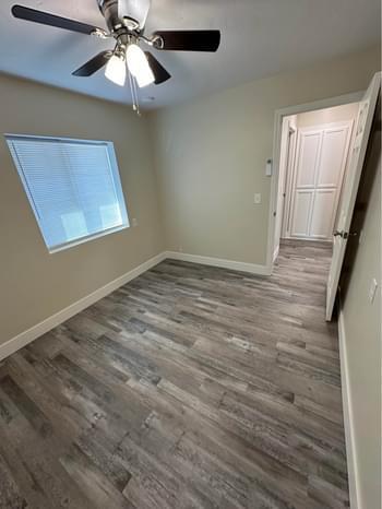 20383 Sutliff Road Escalon, CA 95320 - Photo 31 of 65 an empty room with wooden floor fan and windows