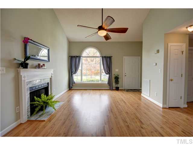 9509 Dawnshire Road Raleigh, NC 27615 - Photo 5 of 24 a view of empty room with fireplace and wooden floor