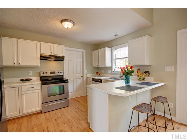 9509 Dawnshire Road Raleigh, NC 27615 - Photo 10 of 24 a kitchen with stainless steel appliances kitchen island granite countertop a sink cabinets and wooden floor
