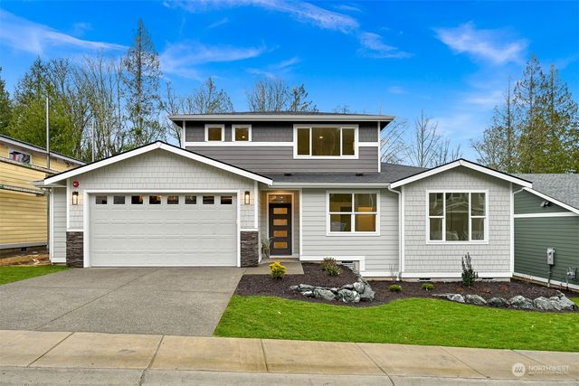 a front view of a house with a yard and garage