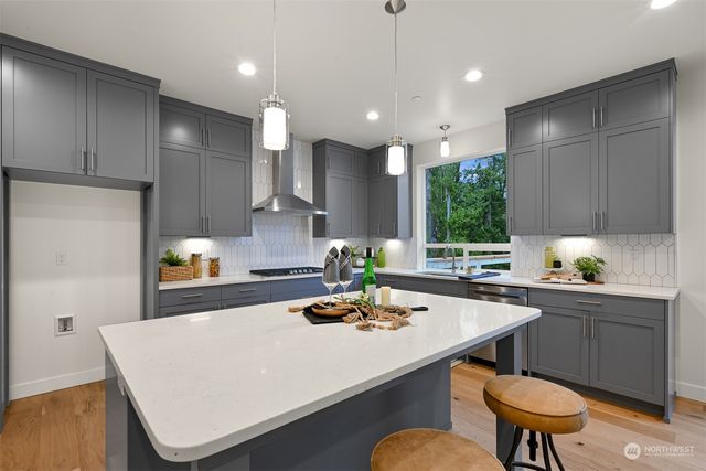 a kitchen with stainless steel appliances a white table chairs and a refrigerator