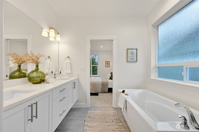 a bathroom with a tub sink and mirror