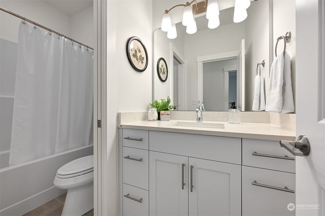 a bathroom with a sink vanity mirror and toilet