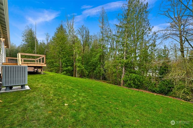 a view of a backyard with lawn chairs with wooden fence