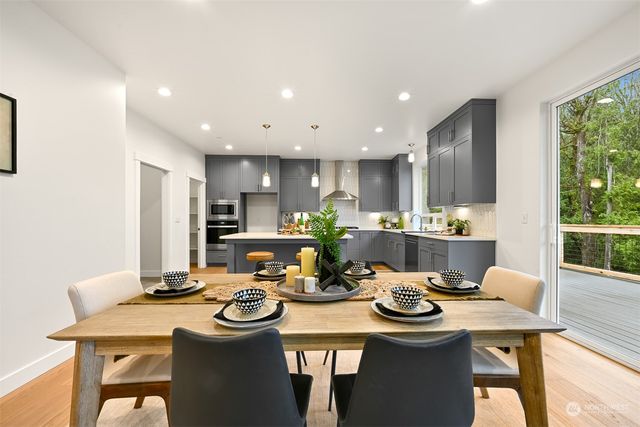 a kitchen with a dining table chairs stove microwave and cabinets