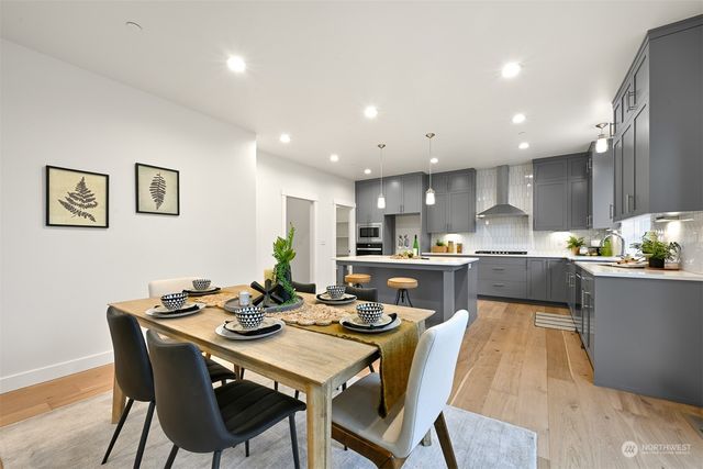 a kitchen with a dining table chairs and wooden floor