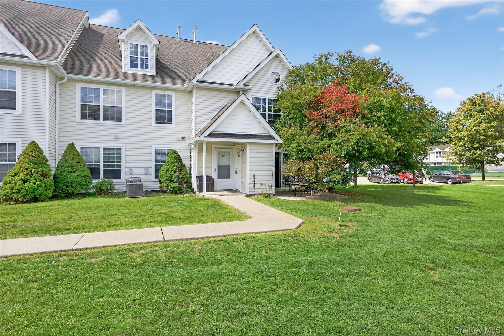 Traditional-style home with roof with shingles and a front lawn