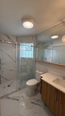 a bathroom with a granite countertop sink toilet and shower