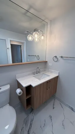 a bathroom with a sink a toilet and mirror