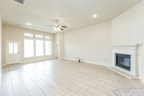 an empty room with a window and a chandelier fan