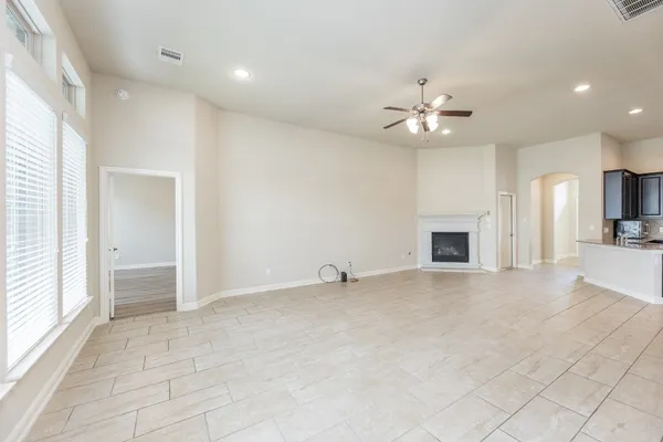an empty room with fireplace and fan