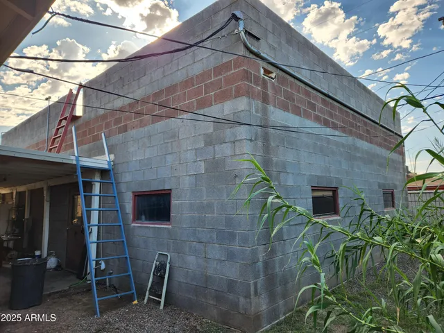 a brick building with a bench and potted plants