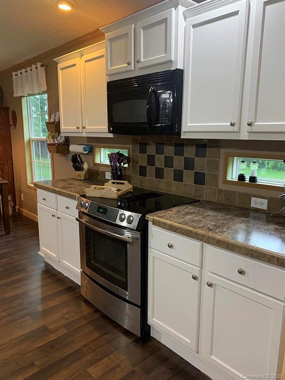 2632 Beaverdam Road Canton, NC 28716 - Photo 4 of 18 a kitchen with stainless steel appliances granite countertop a stove a microwave and a white cabinets