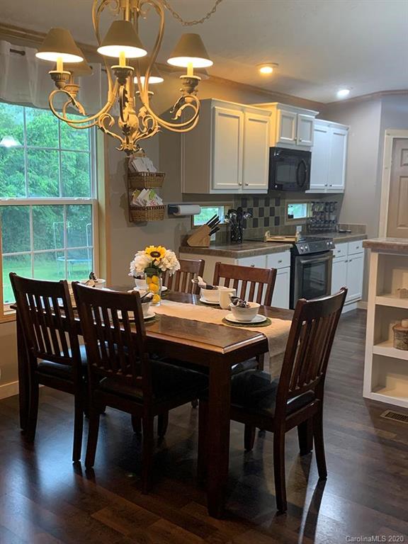 2632 Beaverdam Road Canton, NC 28716 - Photo 6 of 18 a view of a dining room with furniture a kitchen and chandelier