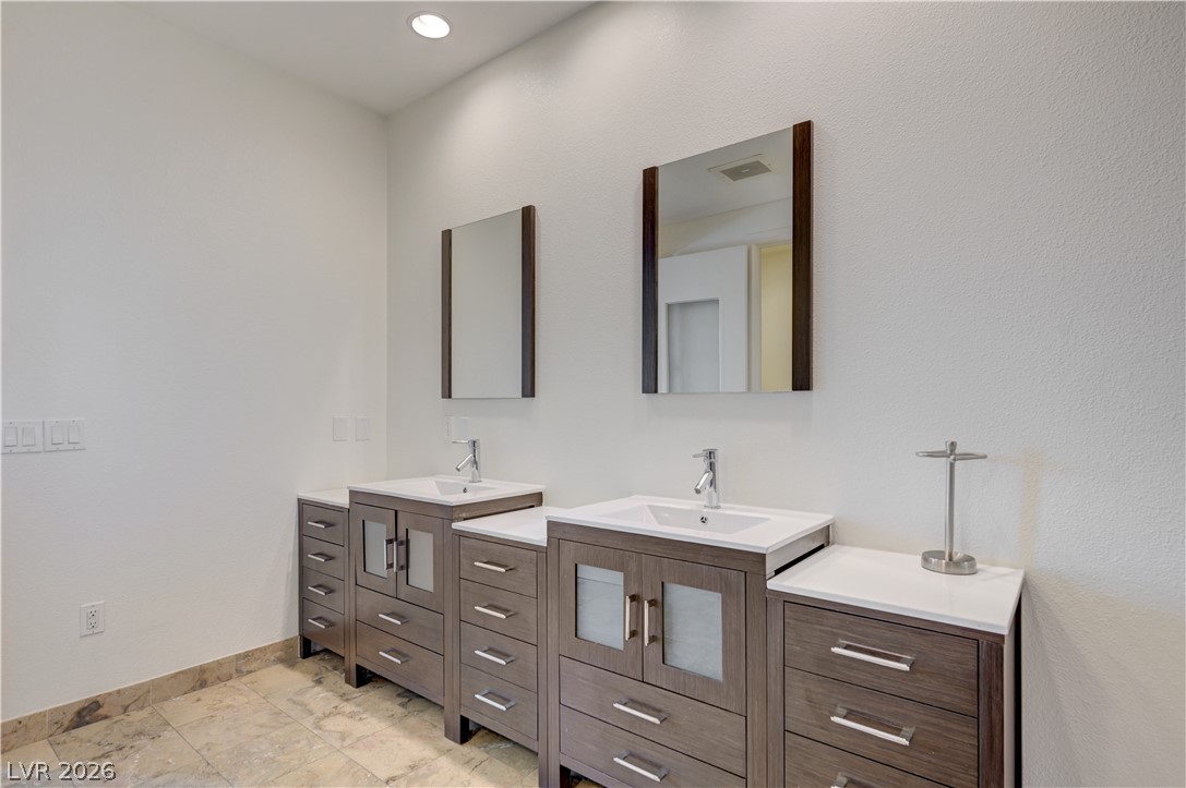 360 East Desert Inn Road, Unit 402 Las Vegas, NV 89109 - Photo 22 of 40 Dual vanities provide ample storage and functional elegance within this well-appointed bath space.