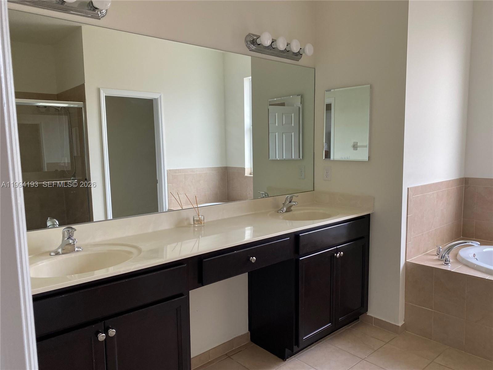 17001 Southwest 90th Terrace, Unit 1 Miami, FL 33196 - Photo 14 of 35 a bathroom with a double vanity sink and mirror with toilet