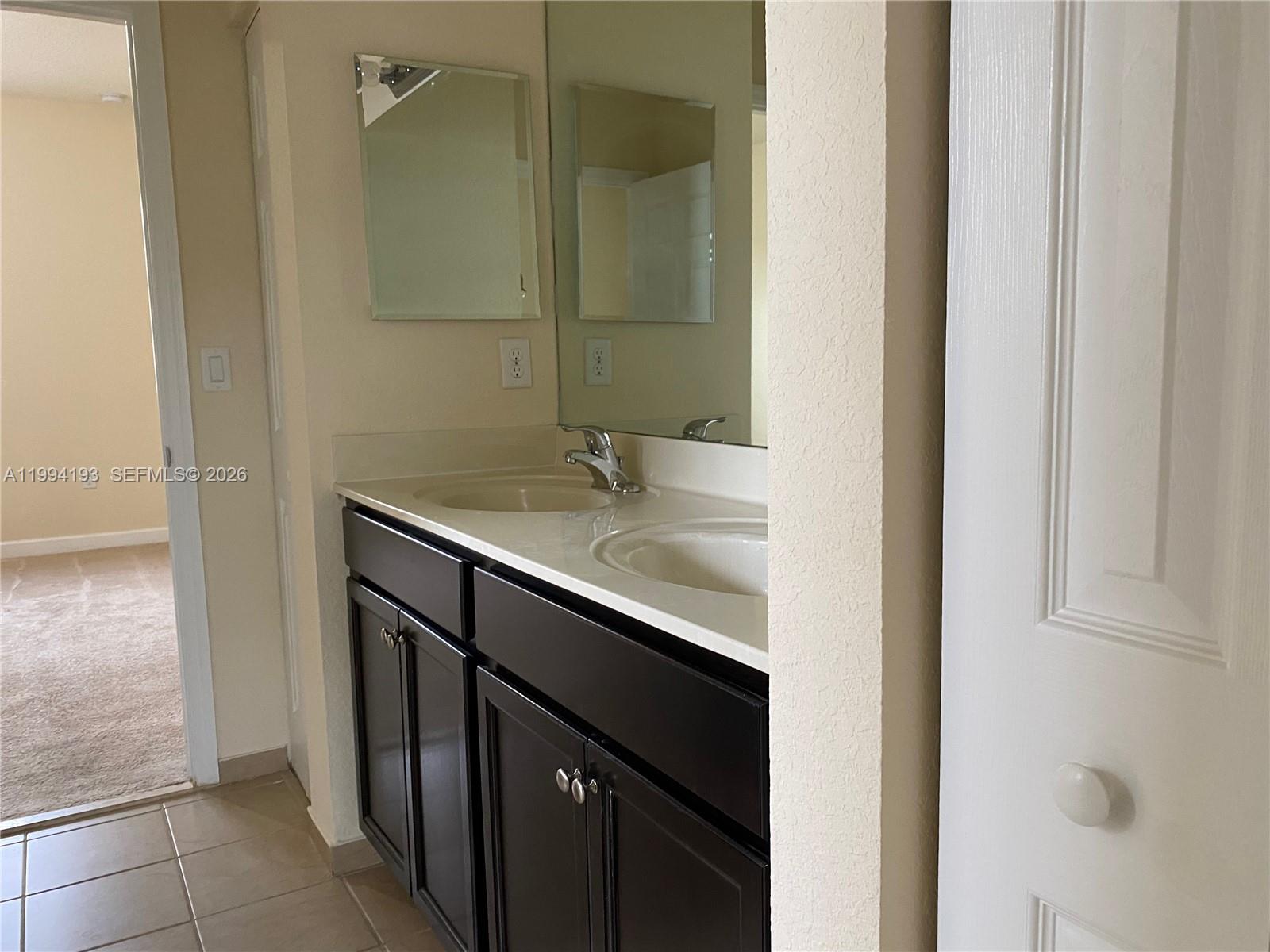 17001 Southwest 90th Terrace, Unit 1 Miami, FL 33196 - Photo 18 of 35 a bathroom with a sink and a mirror