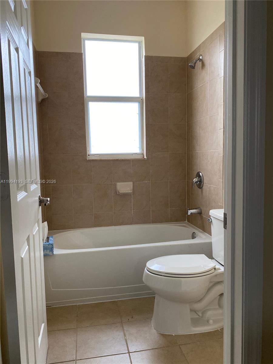 17001 Southwest 90th Terrace, Unit 1 Miami, FL 33196 - Photo 19 of 35 a bathroom with a toilet and a bath tub
