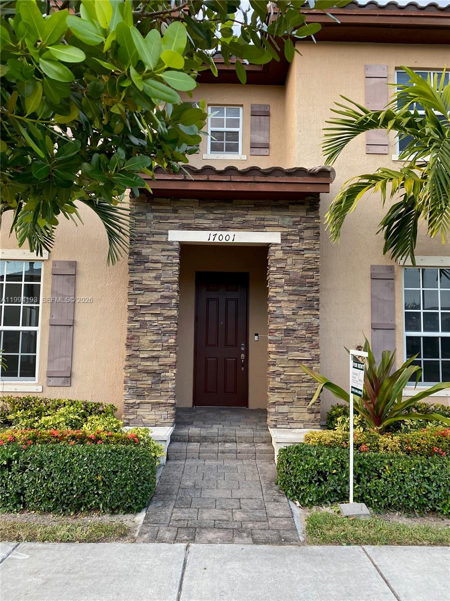 17001 Southwest 90th Terrace, Unit 1 Miami, FL 33196 - Photo 2 of 35 a front view of a house with a garden