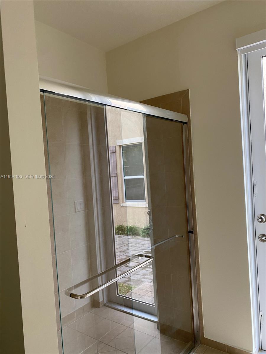 17001 Southwest 90th Terrace, Unit 1 Miami, FL 33196 - Photo 22 of 35 a bathroom with a glass door shower and a sink