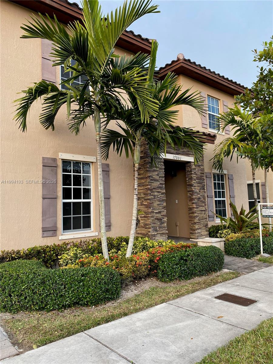 17001 Southwest 90th Terrace, Unit 1 Miami, FL 33196 - Photo 3 of 35 a front view of a house with a yard and garage
