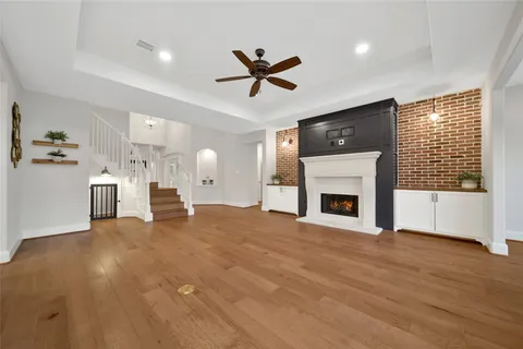 a view of a livingroom with a fireplace a ceiling fan and window