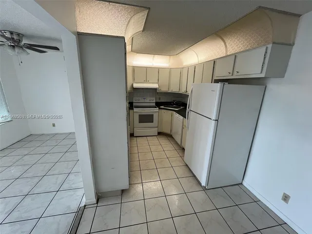 a kitchen with a refrigerator sink and cabinets