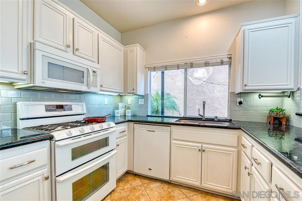 1314 Mill Valley Road Chula Vista, CA 91913 - Photo 12 of 25 a kitchen with granite countertop white cabinets and white appliances