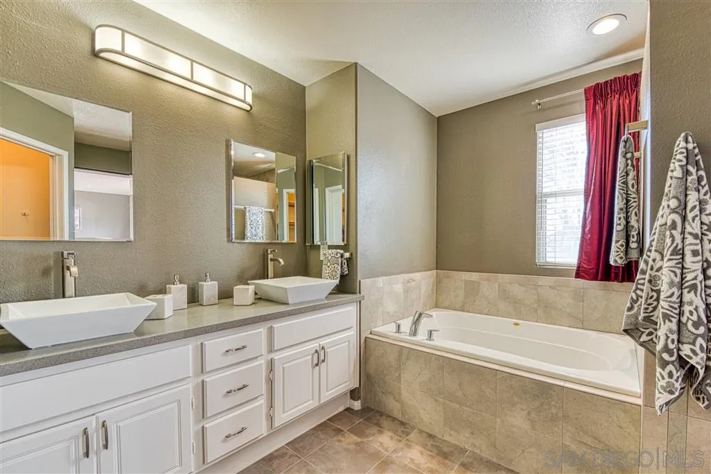 1314 Mill Valley Road Chula Vista, CA 91913 - Photo 17 of 25 a bathroom with a tub a double vanity sink a window and a mirror