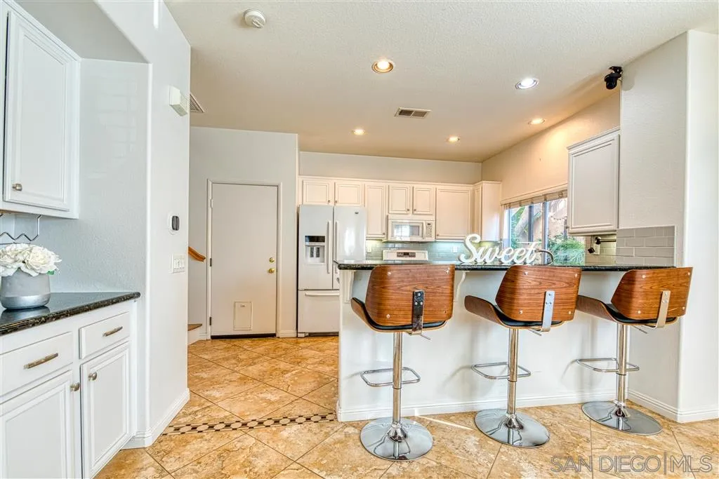 1314 Mill Valley Road Chula Vista, CA 91913 - Photo 10 of 25 a kitchen with stainless steel appliances kitchen island granite countertop a counter top space cabinets and wooden floor