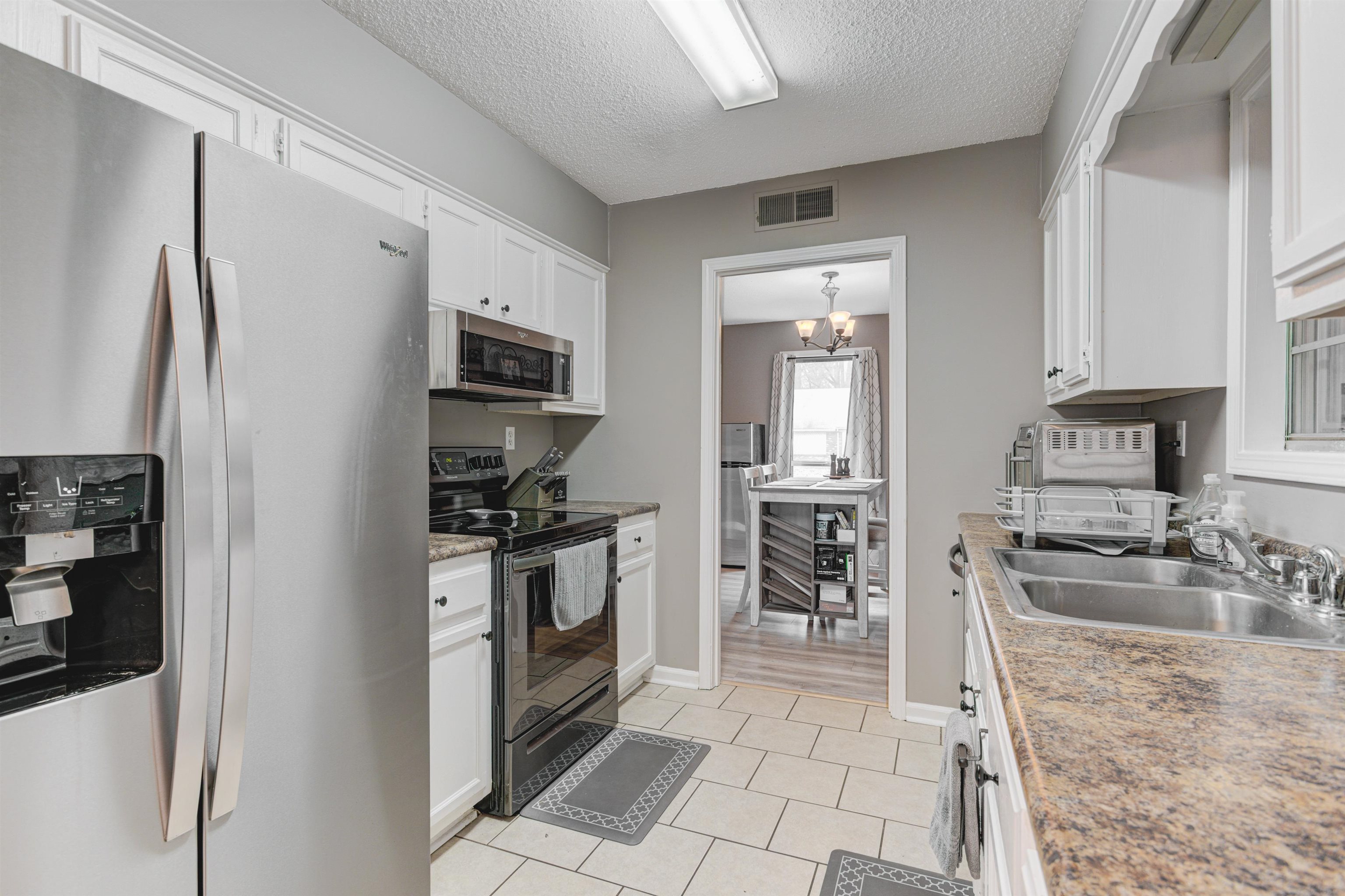 3224 Court Street Bartlett, TN 38134 - Photo 9 of 23 a kitchen with granite countertop a refrigerator and a stove top oven
