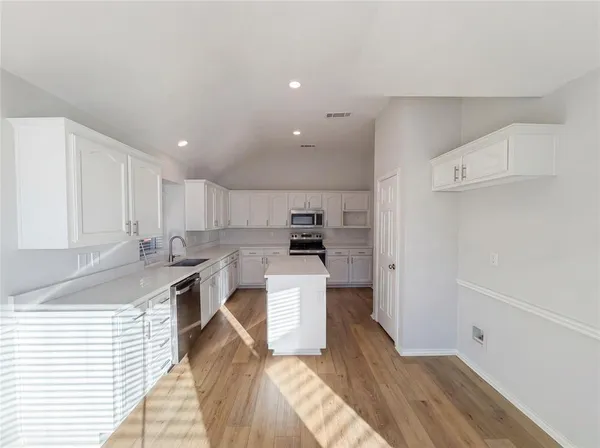 a kitchen with a sink a stove and cabinets