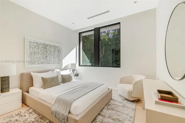 a bedroom with a bed a mirror and a window